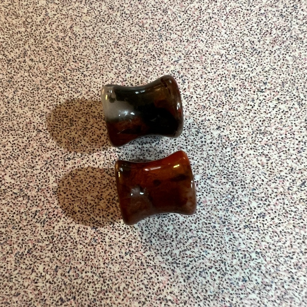Pair of double flare red-gray jasper stone plugs for stretched earlobes.